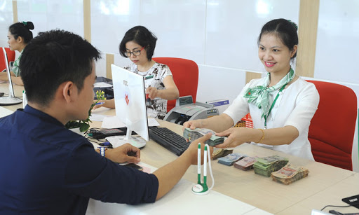 Giao dịch viên ngân hàng tiếp nhận nhu cầu khách hàng